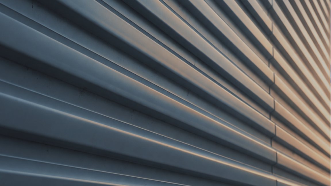 Ribbed metal wall panels catching a warm light